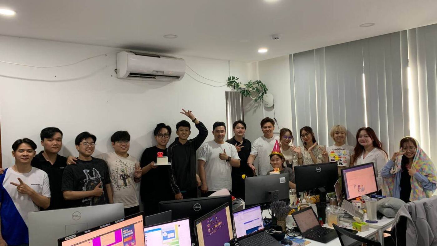 Đội ngũ MONA đứng kín phòng làm việc chụp ảnh cùng nhau